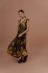 Vestido largo verde militar con estampa tropical de palmeras en tonos amarillos, escote en V y detalles en marrón.