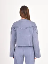 Buzo corto de cuello redondo con efecto lavado, mangas largas con puños elásticos y costuras decorativas horizontales en el pecho.