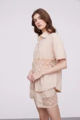 Camisa blanca de algodón con apliques de crochet calado en la cintura, manga corta y cuello camisa.