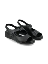 Sandalia de cuero negro con diseño de tiras anchas, ajuste mediante velcro y suela de plataforma baja.