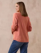 Buzo tejido color salmón de hilado fino, marca Cable & Gauge. Escote redondo con calados. Manga ¾, modelo dolman con aplique de botones dorados.