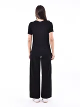 Remera negra de manga corta con estampado de ojos y estrellas en color plateado.