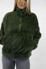 Buzo de peluche color verde oscuro, con cuello alto, cierre frontal parcial y bolsillo tipo canguro.