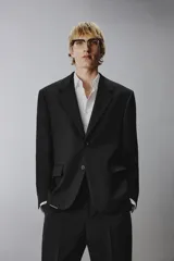 Blazer regular fit de lana color negro, con solapas de muesca, cierre frontal de un botón, bolsillos con solapa en la cadera y manga larga.