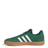 Championes Adidas modelo VL Court 3.0, de diseño urbano con parte superior de gamuza en color verde. Presenta las icónicas tres tiras laterales en color blanco con bordes oscuros, suela vulcanizada de caucho en tono caramelo y cierre con cordones al tono.