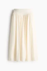 Pollera maxi de corte holgado en mezcla de viscosa, color beige. Cuenta con cintura en punto pesado con detalle fruncido en V que otorga una caída suave y fluida.