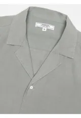 Camisa de manga corta Arrow confeccionada en mezcla de lino y algodón, color azul, con cuello solapa y cierre frontal de botones.