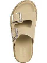 Sandalias de ante color beige con dos tiras anchas ajustables mediante hebillas metálicas plateadas. Presentan una suela de EVA gruesa y dentada de 5,3 cm de altura. Incluyen detalles distintivos de la marca Tommy Jeans en las hebillas y la plantilla.