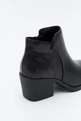 Bota corta de cuero sintético color marrón oscuro, con diseño minimalista, puntera afinada y taco ancho de altura media.