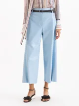 Pantalón wide-leg de tiro alto confeccionado en cuero, color celeste, con bolsillos y detalles de recortes.