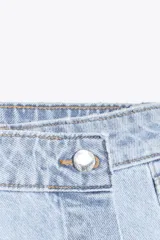 Falda pantalón corta de tiro alto confeccionada en denim celeste. Presenta bolsillos delanteros y traseros. Cierre frontal cruzado con cremallera oculta y botón metálico.