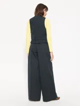 Pantalón de vestir negro con finas rayas verticales blancas, estilo sastrero con pinzas y corte palazzo.