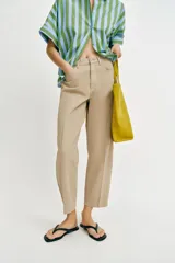 Pantalón de tiro medio con diseño barrel, pernera holgada que se estrecha hacia el tobillo y detalle de raya planchada en el frente y la espalda. Cuenta con cinco bolsillos y cierre frontal con cremallera y botón.