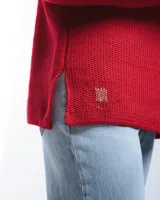 Sweater rojo de lana merino con cuello barco y motivo calado en el lateral.