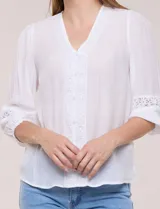 Blusa blanca de manga larga con escote en V y detalles de encaje en la botonera frontal, cuello y puños.