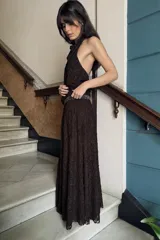 Vestido midi de encaje color marrón oscuro, con cuello halter ajustable con lazadas, detalle de cintura con aplicación de brillos y espalda descubierta. El bajo tiene un acabado en línea evasé.