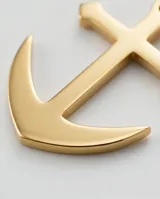 Dije de acero con baño de oro en forma de ancla, con acabado pulido brillante.