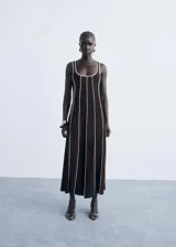 Vestido midi de algodón color marrón con diseño de rayas verticales en relieve de color blanco. Presenta cuello escotado, tirantes anchos y un corte recto.