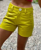 Shorts de cuero color amarillo lima, con cierre frontal de botón blanco y bolsillos laterales.