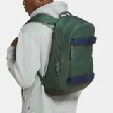 Mochila Nike SB Courthouse color verde con correas frontales ajustables en color azul, ideales para sujetar una tabla de skate. Cuenta con compartimento principal amplio y cierre vertical.