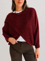 Capa tejida de diseño cruzado en el frente, con mangas tipo murciélago y calce holgado. Presenta una textura de punto suave y abrigada.