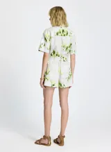 Short de tela con estampado floral en tonos blanco, verde y amarillo. Cintura elástica con cordón ajustable y puntas metálicas, bolsillos laterales y traseros.