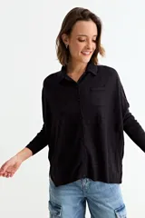 Cardigan de punto color crema, con cuello camisero, cierre frontal de botones y bolsillo frontal en el pecho.