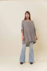 Maxi sweater tejido de silueta amplia con efecto metalizado sutil. Diseño oversize con mangas amplias tipo murciélago y caída fluida. Largo asimétrico, más corto adelante y más largo atrás. Terminaciones en rib.