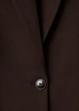Chaqueta Gabi de corte recto y color marrón oscuro, con cuello de solapa con muesca, mangas largas con puños abotonados, cierre frontal de un botón y bolsillos con solapa en el frente.