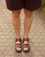 Sandalias de cuero color marrón chocolate, con tiras en el empeine, suela flatform track negra y tira con cierre ajustable en el talón.