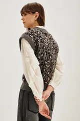 Chaleco de punto con diseño de animal print de leopardo en tonos grises y negros, con cuello redondo y corte sin mangas.