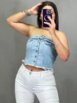 Top strapless de jean celeste con botones plateados al frente y ruedo desflecado.