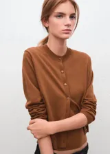 Cardigan de punto fino color marrón, de corte recto, con cuello redondo, manga larga y cierre frontal con botones.