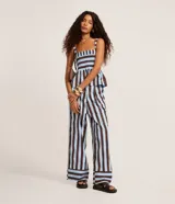 Pantalón de cintura alta, confeccionado en tricolina de algodón, con cierre tradicional, pliegues y rayas verticales en azul claro y marrón.