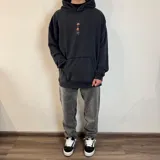 Canguro negro con capucha y corte oversize. Estampado en la espalda con el texto "Underwave Brand", un cangrejo y la frase "Surf N' Destroy".