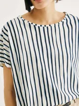 Blusa de manga corta con cuello redondo y estampado de cuadrícula blanca sobre fondo color tostado.