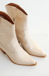 Bota texana color beige con textura símil piel de cocodrilo, caña media, punta fina y taco de madera.