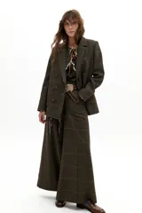 Pantalón de pierna ancha con estampado de cuadros en tonos verde musgo y líneas naranjas. Presenta tiro medio-alto, cierre frontal oculto y bolsillos laterales de apertura diagonal.