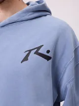 Canguro con capucha de calce holgado, color azul con efecto lavado. Presenta bolsillo frontal tipo canguro, logo de la marca estampado en el pecho y etiqueta pequeña en el ruedo.