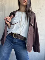 Blusa oversize de color blanco con diseño romántico y bohemio, confeccionada con detalles de encaje y botones forrados en el frente. Cuenta con mangas largas.