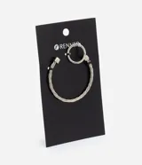 Kit de bijouterie compuesto por una pulsera rígida con diseño trenzado y un anillo minimalista de metal plateado.