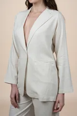 Blazer de lino y viscosa color beige con calce relajado, solapa clásica, cierre de un botón y bolsillos delanteros con solapa.
