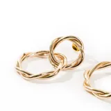 Aros colgantes dorados con forma de eslabones entrelazados.