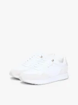 Zapatillas de piel Tommy Hilfiger de corte bajo, color blanco con paneles de ante en tono gris claro, inspiradas en modelos de running retro con suela de EVA y detalles distintivos.