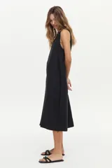 Vestido midi color crudo de corte relajado, con caída fluida, sin mangas y escote en V.