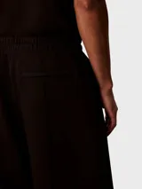 Pantalón de felpa negro Calvin Klein, de corte regular y pierna recta, con costuras delanteras decorativas y logo bordado en el muslo.