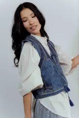 Chaleco de jean azul con bordados y estampado en el interior.