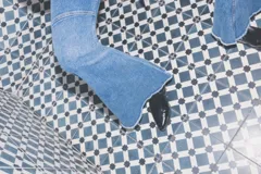 Jeans de corte flare y tiro medio, en color azul, con diseño acampanado y detalles de costuras en las piernas.