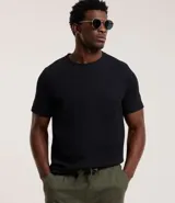 Remera de manga corta y cuello redondo, confeccionada en tejido de media malla con textura vertical. Presenta un diseño minimalista y ligero, ideal para un uso versátil y cómodo.