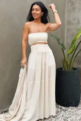 Conjunto compuesto por un top fruncido strapless de algodón con detalle de lurex y una falda larga fluida de talle alto con volantes y cintura fruncida.